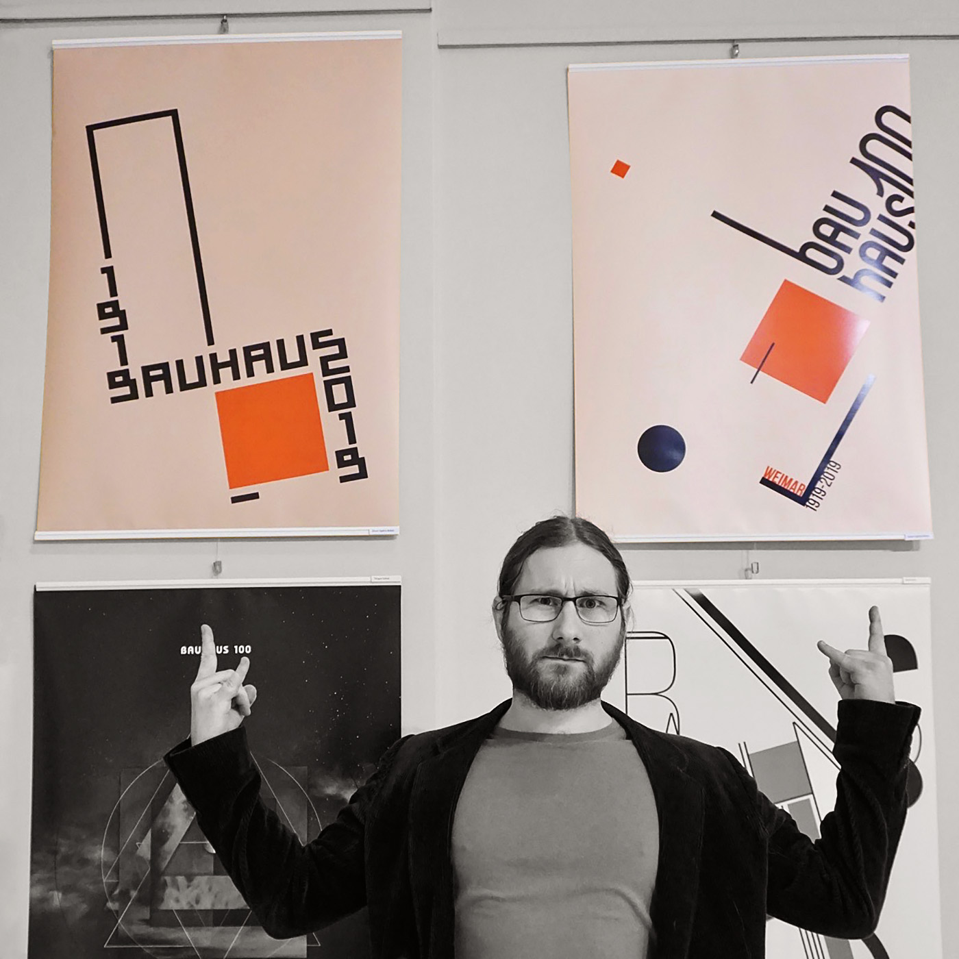 Graphic designer standing in front of his posters designed for the Bauhaus 100 exhibition